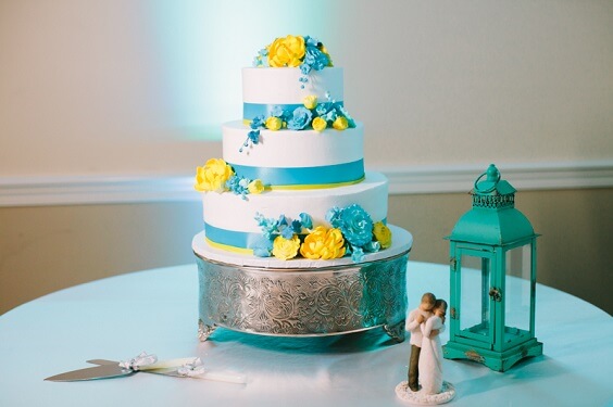 wedding cake with turquoise ribbon and yellow flowers for summer turquoise wedding