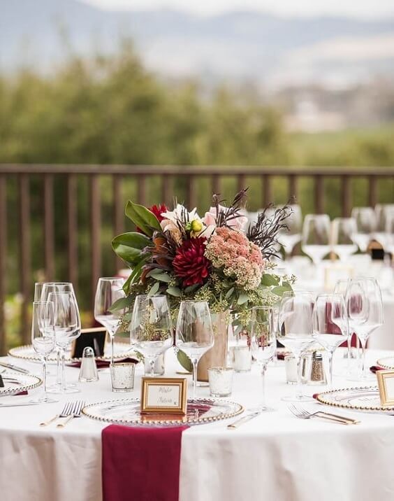 Table decorations for champagne and burgundy winter wedding