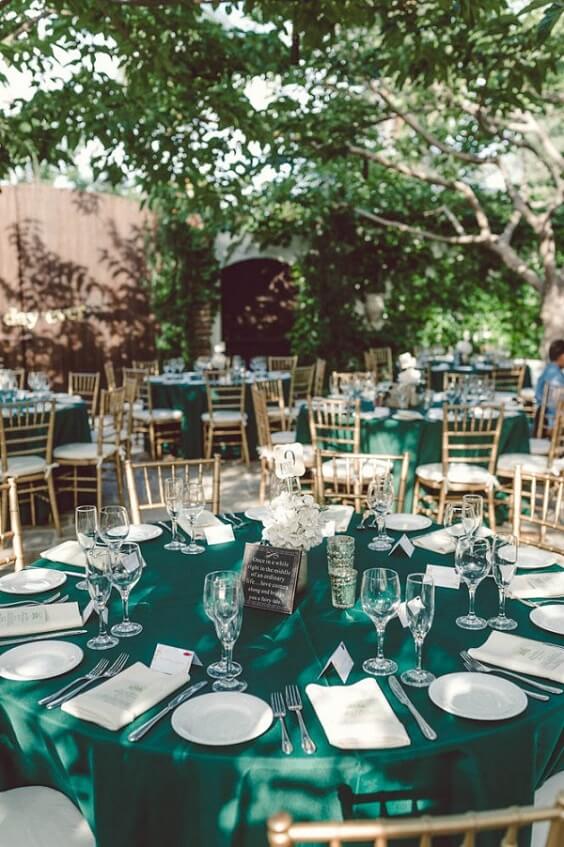 emerald green table cloth and gold chairs for winter wedding colors 2022 emerald green and gold