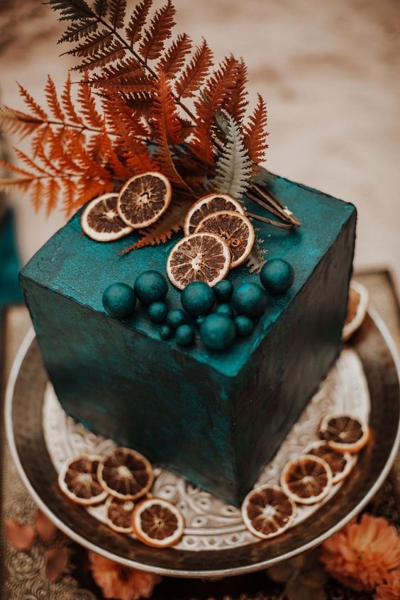 emerald green wedding cake dotted with brown leaves for fall wedding colors 2023 emerald and brown
