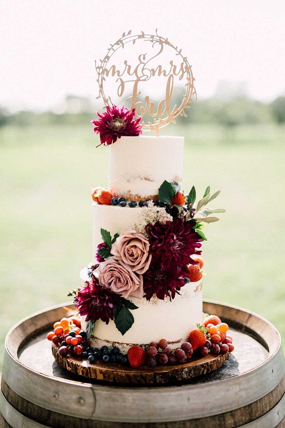 burgundy wedding cake dotted with burgundy flowers gold cake topper for fall wedding colors 2023 burgundy and gold