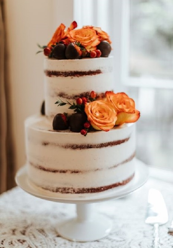 wedding cake dotted with burnt orange flower for fall wedding colors 2023 teal and orange