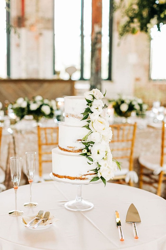 white wedding cake with greenery for fall wedding colors 2023 champagen and greenery