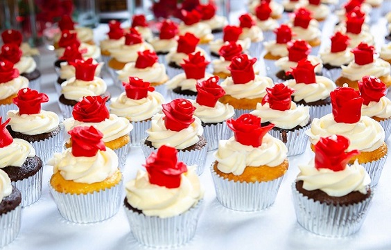 yellow wedding cupcake dotted with red cream flowers for fall wedding colors 2023 red and yellow