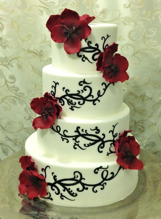 white wedding cake dotted with black and red flowers for red and black wedding colors red black and white