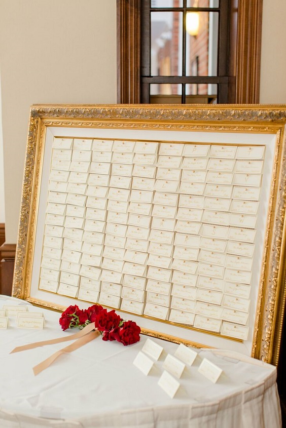 gold framed escort card display for red and black wedding colors red black and gold