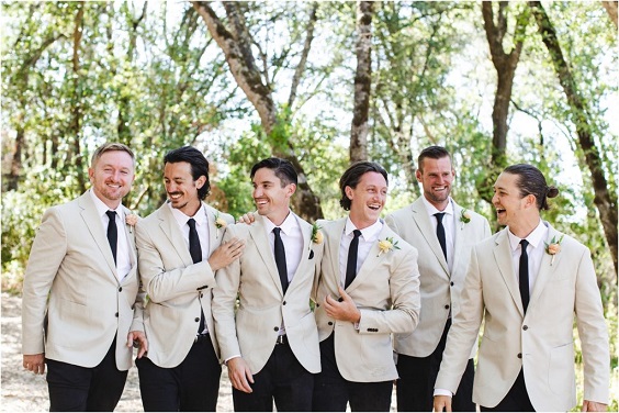groom and groomsmen in champagne suits black tie and black pants for red and black wedding colors red black and champagne