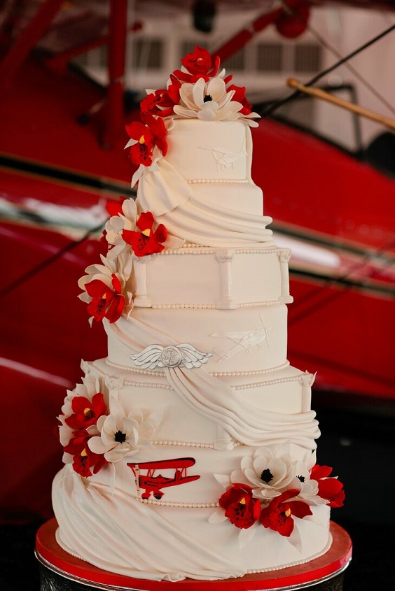 white wedding cake dotted with red roses for red and black wedding colors red black and silver