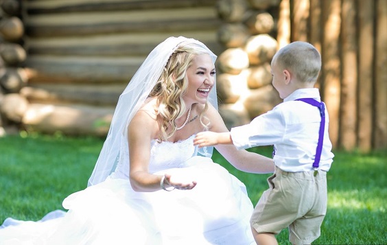 ring bearer boy in champagne pants and royal blue suspenders for purple wedding colors 2023 lavender and royal blue