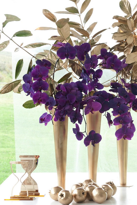 gold vase with purple flowers and gold leaves for purple wedding colors 2023 purple and gold