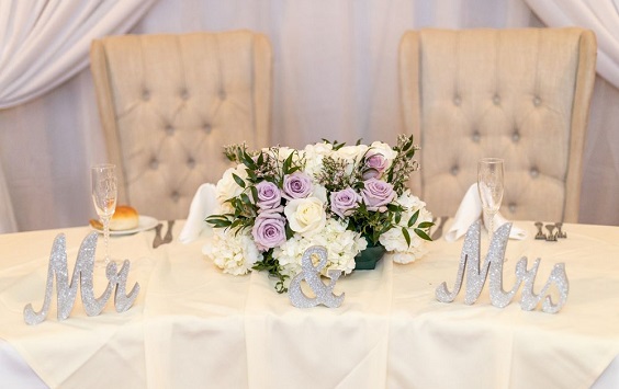 sweetheart table with mauve flower and greenery centerpieces for purple wedding colors 2023 shades of mauve