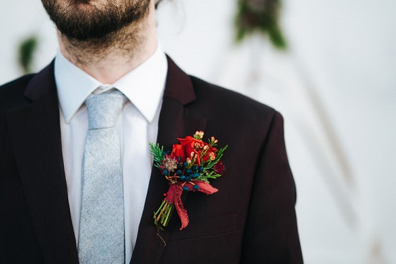 black mens suit and red boutonniere for winter wedding colors 2023 red green and white