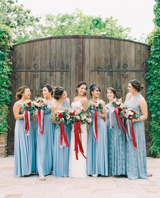 dusty blue bridesmaid dresses holding bouquets in red sashes for red wedding colors 2023 red and dusty blue