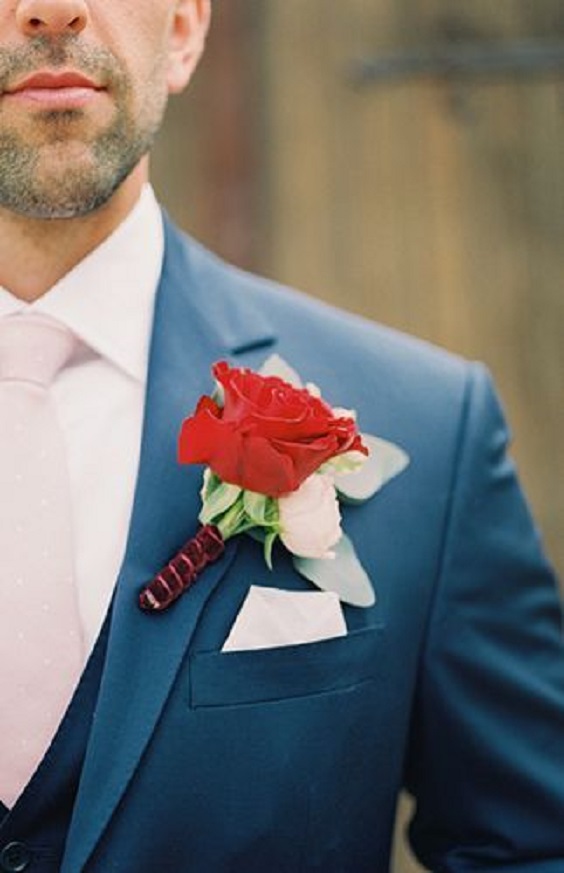 groom in blue suits with red flower corsage for red wedding colors 2023 red and dusty blue