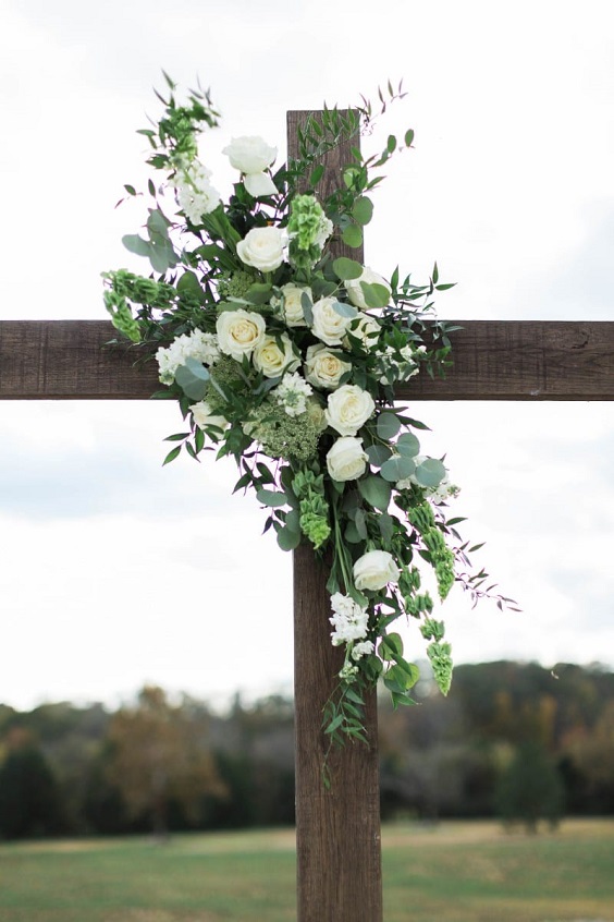 white flower and greenery decorated wedding arch for august wedding colors 2023 navy white and greenery