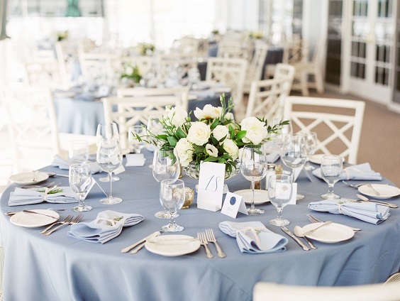 salte blue wedding tablelinen and napkins and white and greenery centerpieces for blue wedding colors 2023 slate blue green and white