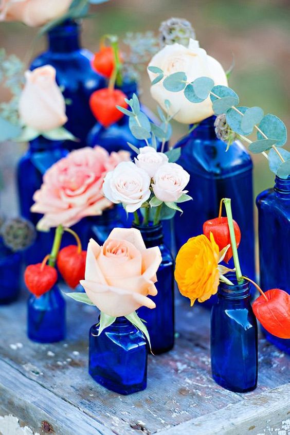 coral and light pink flowers in royal blue vases for blue wedding colors 2023 royal blue and coral