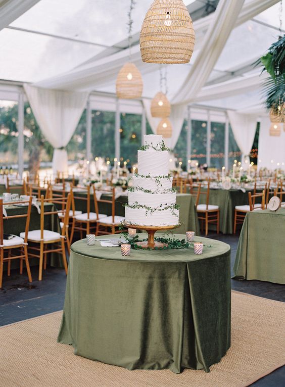 olive green wedding tablecloth and white wedding cake dotted with greenery for november wedding colors 2023 olive green and white