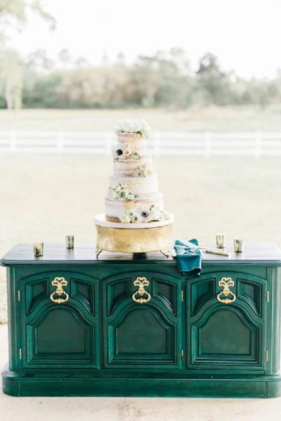 white wedding cake on hunter green cupboard for green wedding theme 2023 hunter green colors