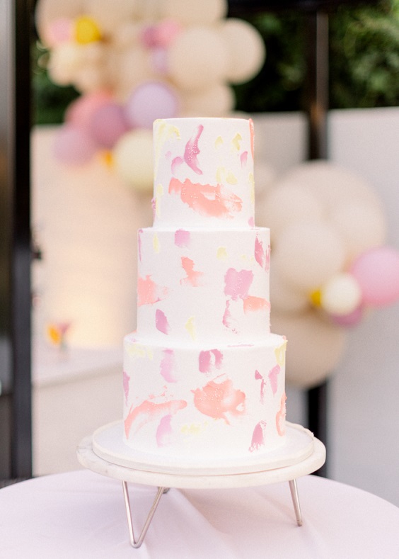 white wedding cake with peach and pink cream for april wedding color schemes for 2023 champagne and peach