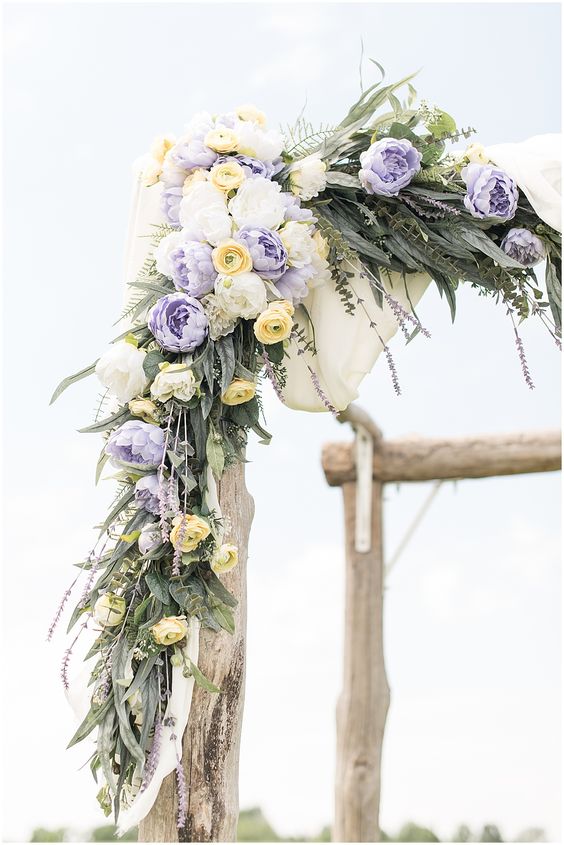 lavender yellow and white flower and greenery wedding arch for april wedding color schemes for 2023 lavender and yellow