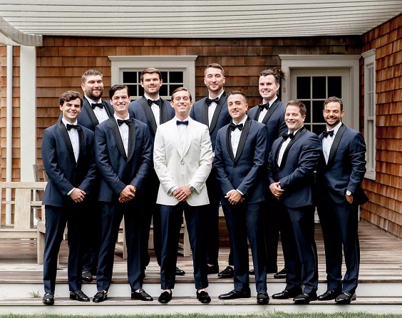 navy blue groomsmen suits and black bowties for april wedding color schemes for 2023 shades of blue