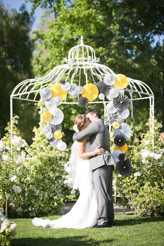 wedding backdrop decorated with gray and yellow paper umbrellas for yellow weddding themes for 2023 yellow and gray