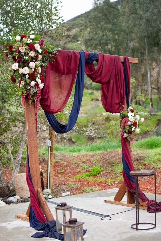 navy blue and burgundy cloth decorated wedding arch for navy blue wedding themes for 2023 navy blue and burgundy