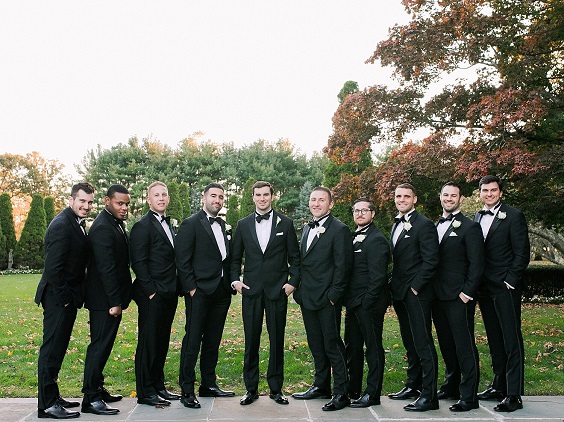 black men suits white bowties and white flower corsage for navy blue wedding themes for 2023 navy blue white and black