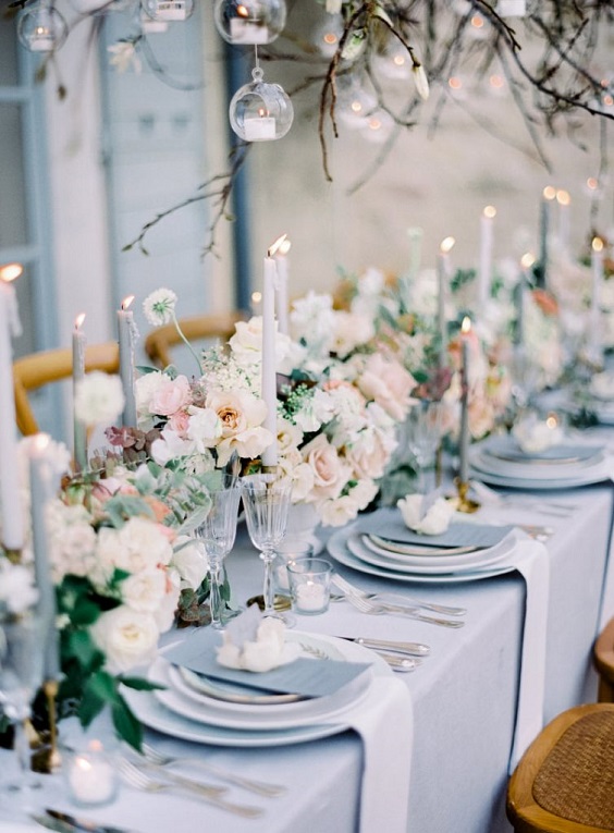 blush pink and white flower centerpieces and dusty blue candles for dusty blue wedding themes for 2023 dusty blue and blush pink