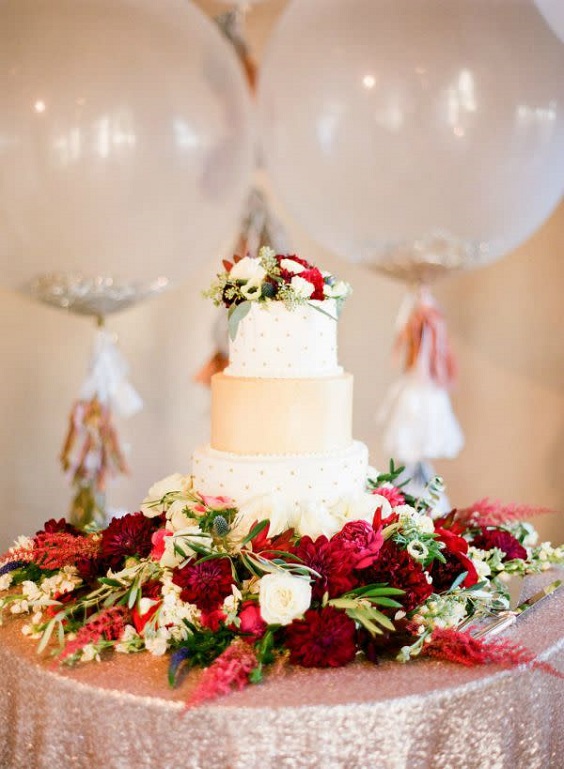 wedding cake dotted with burgundy flowers for dusty blue wedding themes for 2023 dusty blue and burgundy