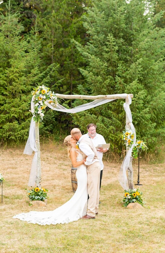 wedding arch with yellow and white flowers and greenery for dusty blue wedding themes for 2023 dusty blue and yellow
