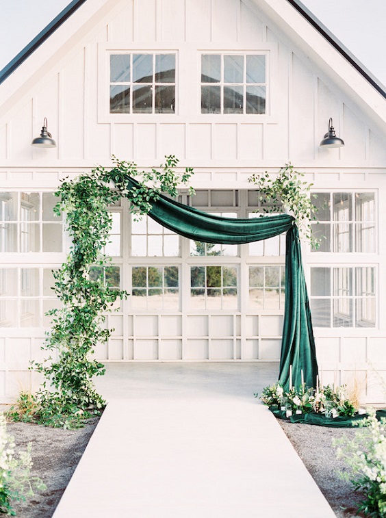 emerald cloth and greenery wedding arch for emerald green wedding color schemes for 2024 emerald green and black