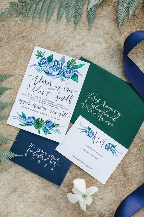 navy and emerald green wedding invitation suite with painted blue flowers and a silk ribbon for emerald green wedding color schemes for 2024 emerald green and navy blue