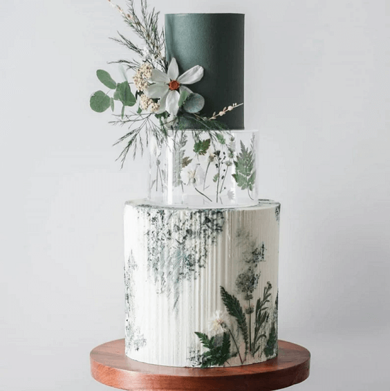 white green wedding cake with green greenery for march wedding colors combos for 2024 sage green and whisper white