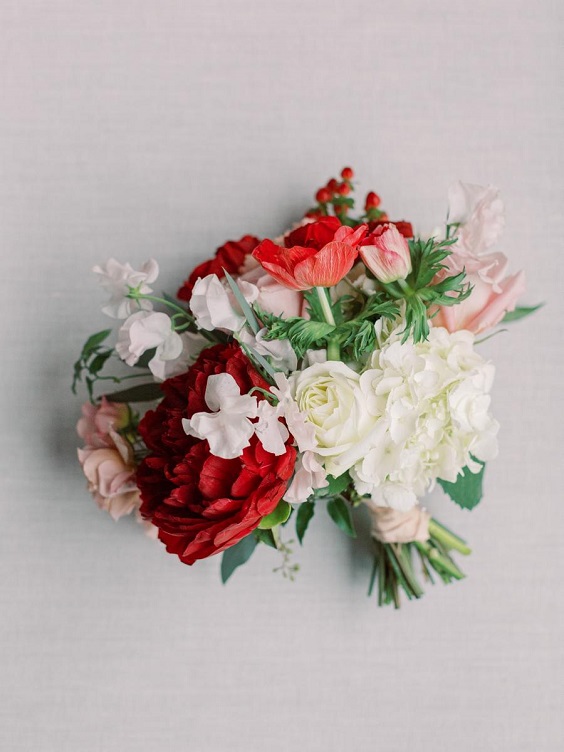white and red flowers and greenery bridal bouquet for january wedding colors for 2024 emerald green and red