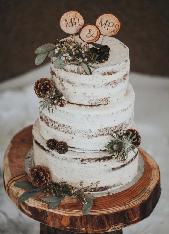 nude wedding cake dotted with brown pinecones for january wedding colors for 2024 sage green and brown