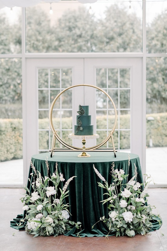 emerald wedding cake in a gold circle on emerald tablecloth desk for emerald green and gold wedding colors emerald gold and white