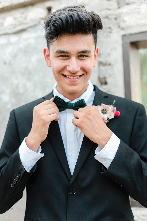 black bridegroom suit with emerald bowtie and light fuschia corsage for emerald green and gold wedding colors emerald gold and fuschia