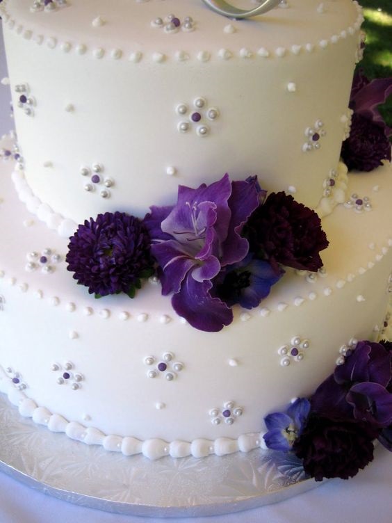 white wedding cake with royal purple flowers for purple wedding colors combos for 2024 royal purple and chalk violet