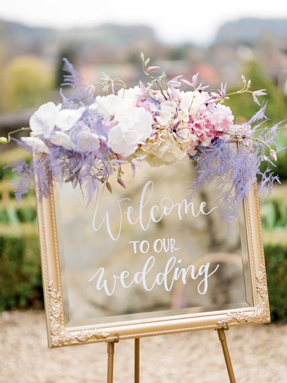 welcome wedding sign with pastel lilac white pink flowers for july wedding colors combos for 2024 pastel lilac and white
