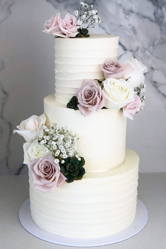 white wedding cake with pastel lilac white flowers for july wedding colors combos for 2024 pastel lilac and white