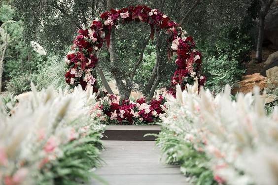 circle wedding arch with burgundy and pink flowers for july wedding colors combos for 2024 burgundy and ivory