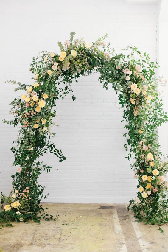 b2677 wedding ceremony arch with pastel yellow flowers for july wedding colors combos for 2024 pastel yellow and ivory