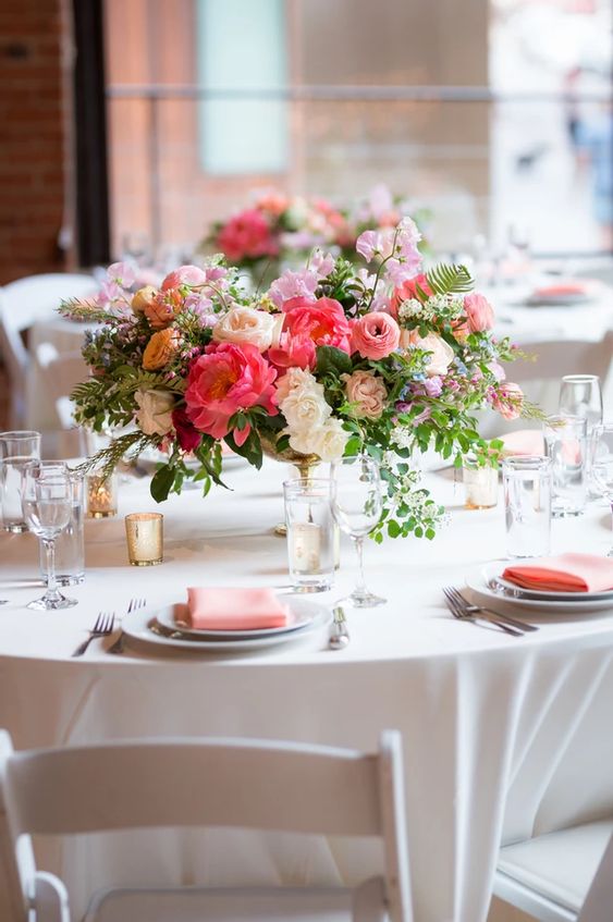 coral kerchief and white pink coral flowers at table for july wedding colors combos for 2024 coral and cream