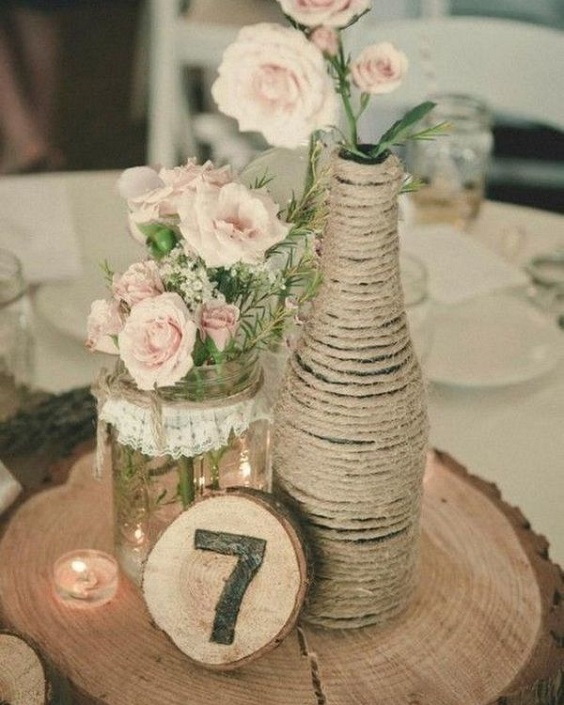 blush flower in bottle and jar on brown wood stump wedding centerpieces for country wedding colors for 2025 navy blue blush and brown