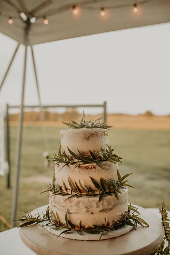 naked wedding cake dotted with greenery for country wedding colors for 2025 sage green and white