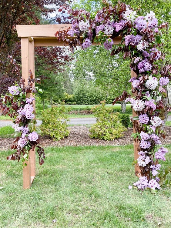 wooden wedding arch dotted with lavender flowers for navy blue wedding colors for 2025 navy blue lavender and violet