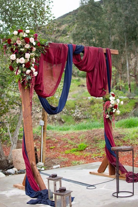 wedding arch with navy bule and red clothes and red pink flowers for blue wedding colors combos for 2025 navy blue and red