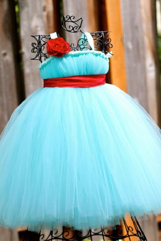 a turquoise junior bridesmaid dress with a red flower and a red sash for blue wedding colors combos for 2025 turquoise and red
